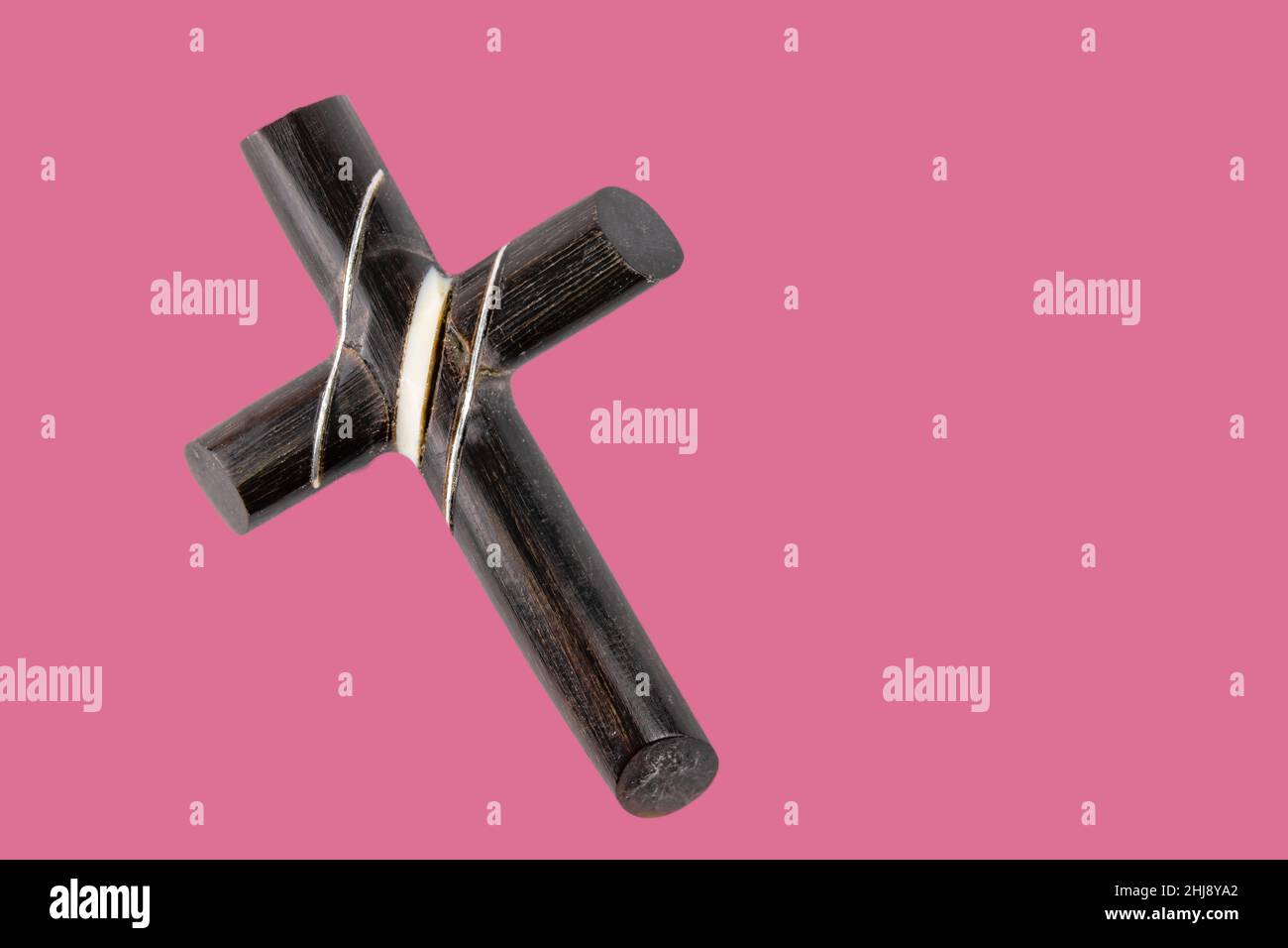 Christian cross symbol over a pink background Stock Photo