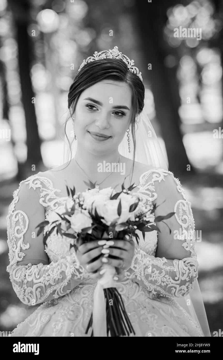 Portrait of a bride in a beautiful white dress on a green background ...