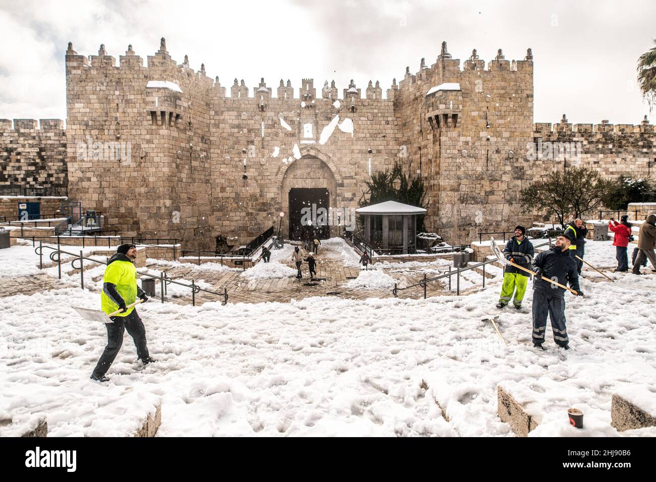 Palestinian youth shavel the snow and play on the steps of Damascus Gate. Jerusalem, Israel. Jan 27th 2022. ( Credit: Matan Golan/Alamy Live News Stock Photo