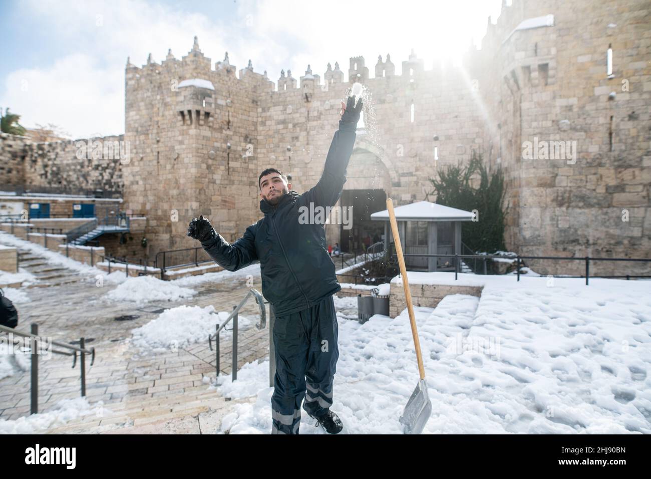 Palestinian youth shavel the snow and play on the steps of Damascus Gate. Jerusalem, Israel. Jan 27th 2022. ( Credit: Matan Golan/Alamy Live News Stock Photo