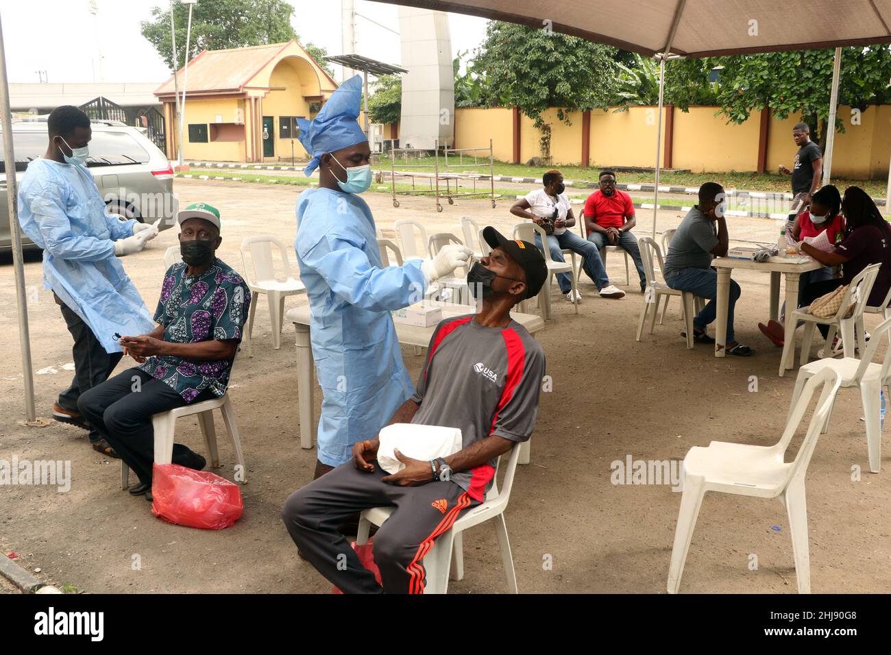Healthcare workers wearing personal protective equipment (PPE) collects