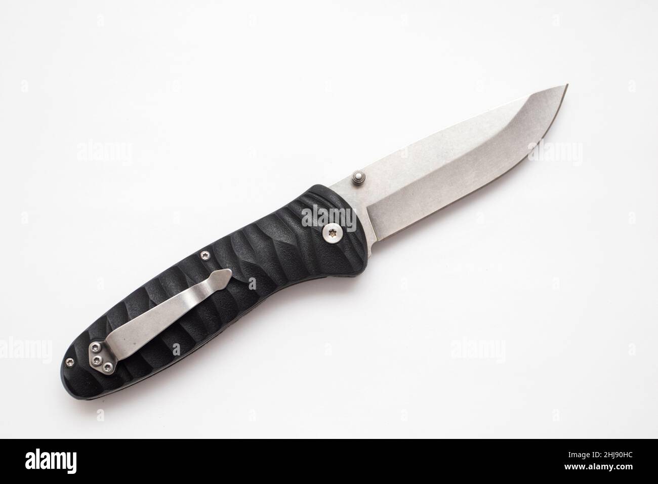 Folding hunting knife with black handle on white background. Stock Photo