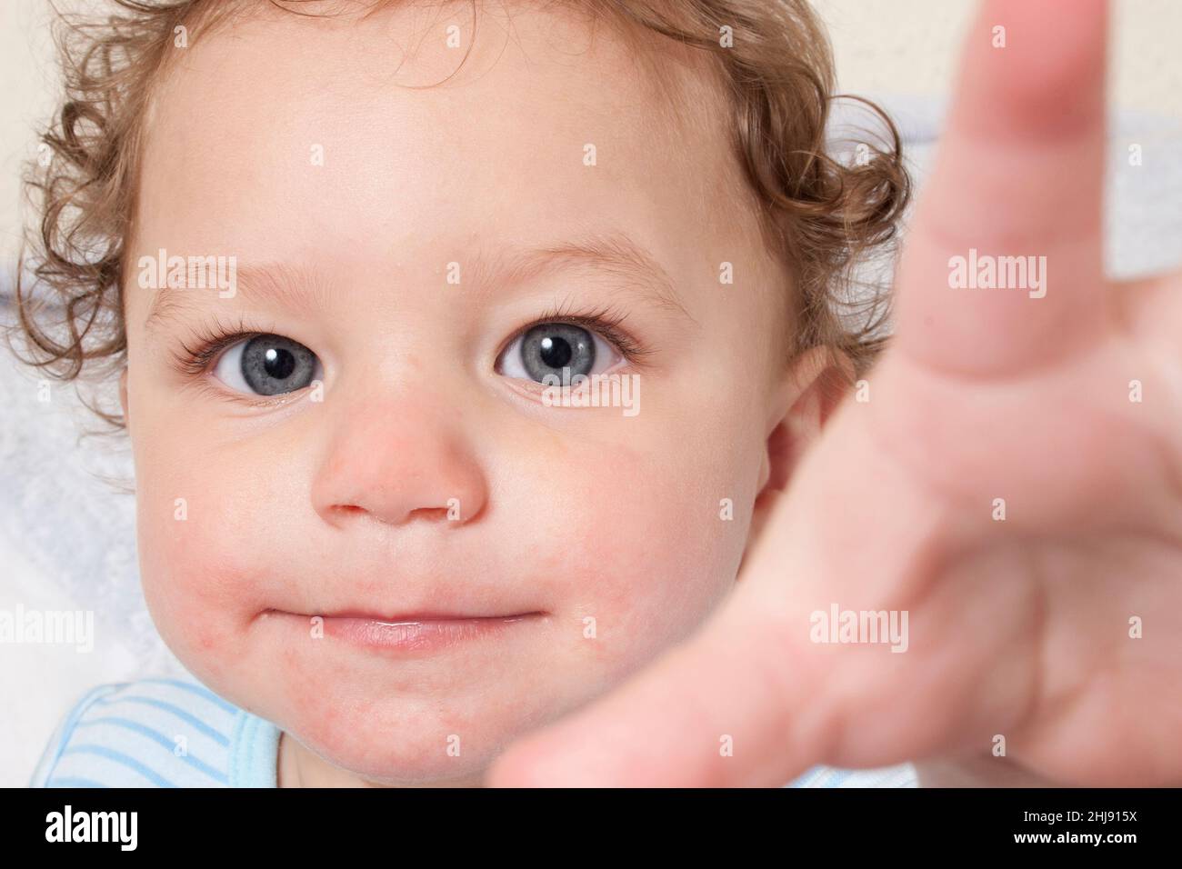 cheeky baby thrusting his hand into camera Stock Photo
