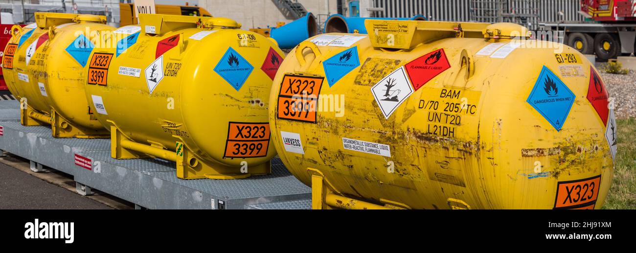 3 hazmat container transport vessels for a liquid, water-reactive, flammable organometallic substance over a spill protection container UN number 3399 Stock Photo