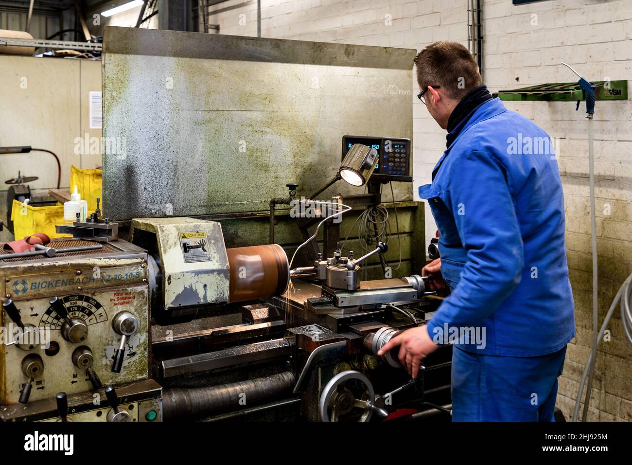 A worker at a lathe machine Stock Photo