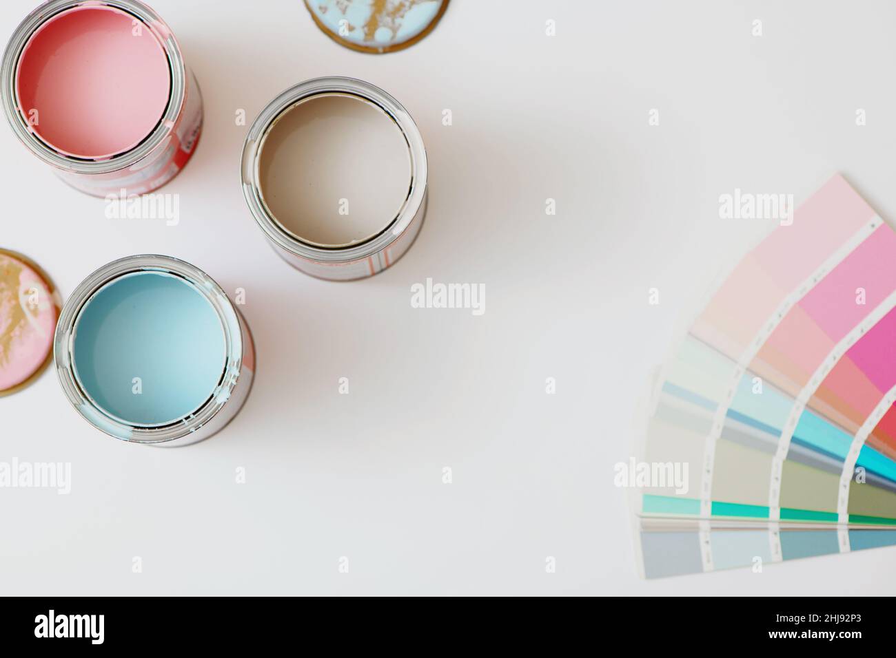 Top view of cans with paint and color palette on white background. Stock Photo