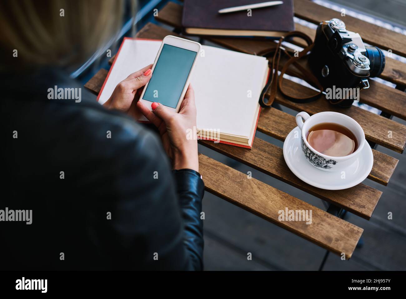 Faceless woman using smartphone in cafeteria Stock Photo