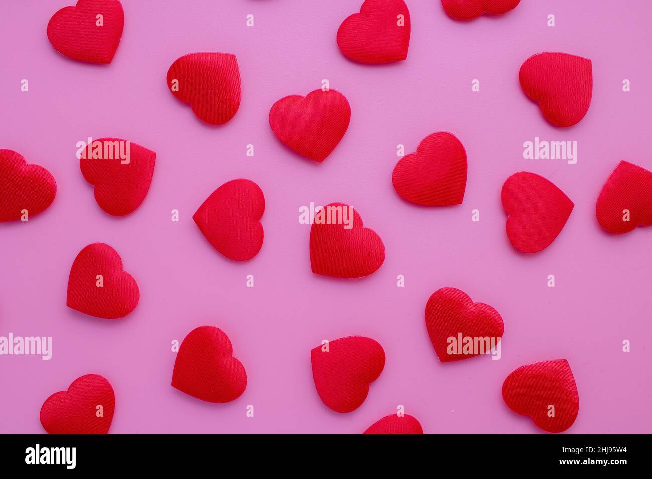 The magical paradise of hearts. Lots of perfectly shaped hearts are placed on a bright pink background. Made of fabric, stylish and romantic backgroun Stock Photo