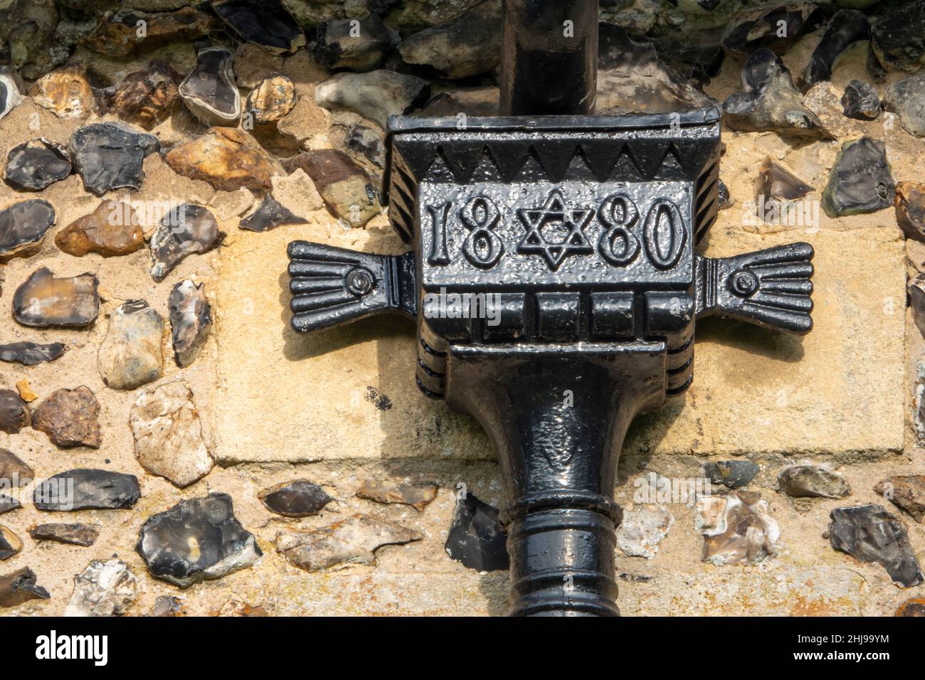 Cast iron drain pipe hopper dated 1880 with edge decorations and central hexagram motif Stock Photo