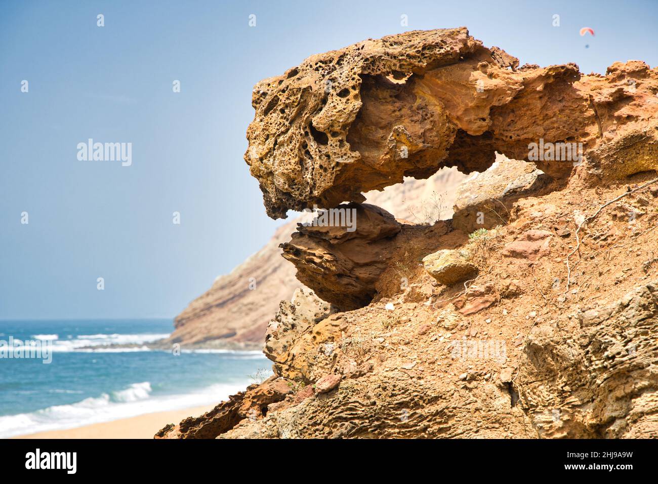 Shot of a sandy big rock made by nature geological formation by the sea ...
