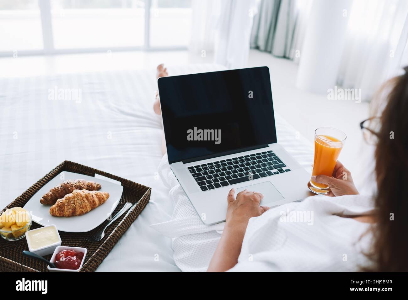 Crop woman using laptop on bed Stock Photo - Alamy