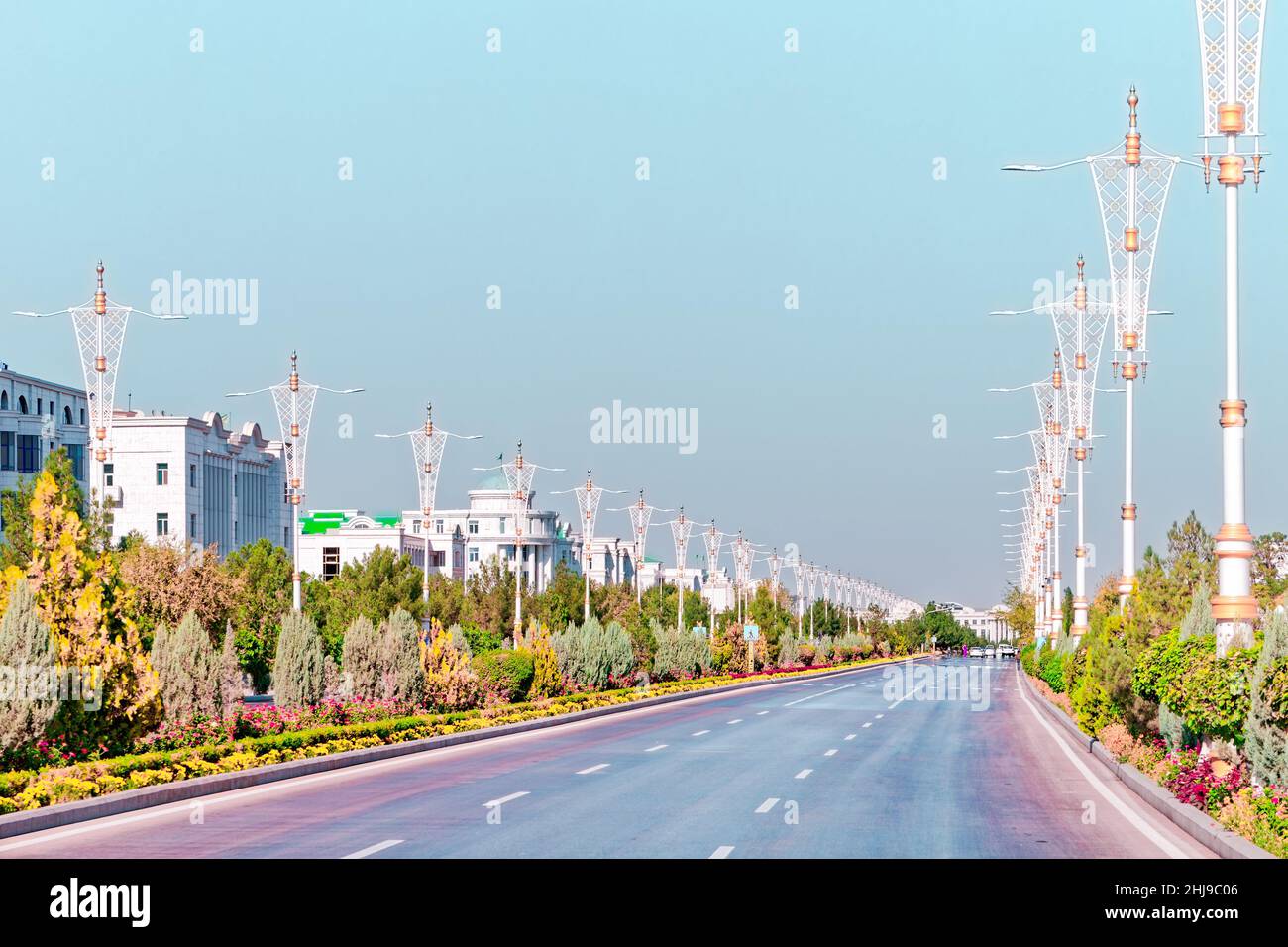 Urban city scape of Ashgabat city center with wide highway and light traffic. High white marble buildings by sides. Ashgabat is the capital of Turkmen Stock Photo