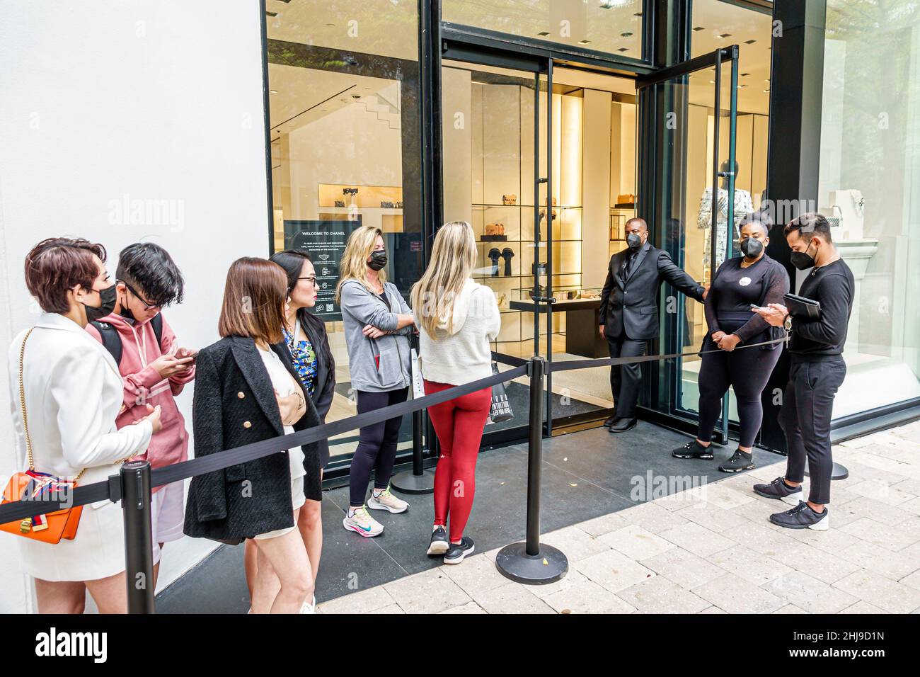 Miami Florida Design District shopping shoppers Chanel French luxury fashion designer clothing line queue entrance exterior outside store wear Stock Photo -