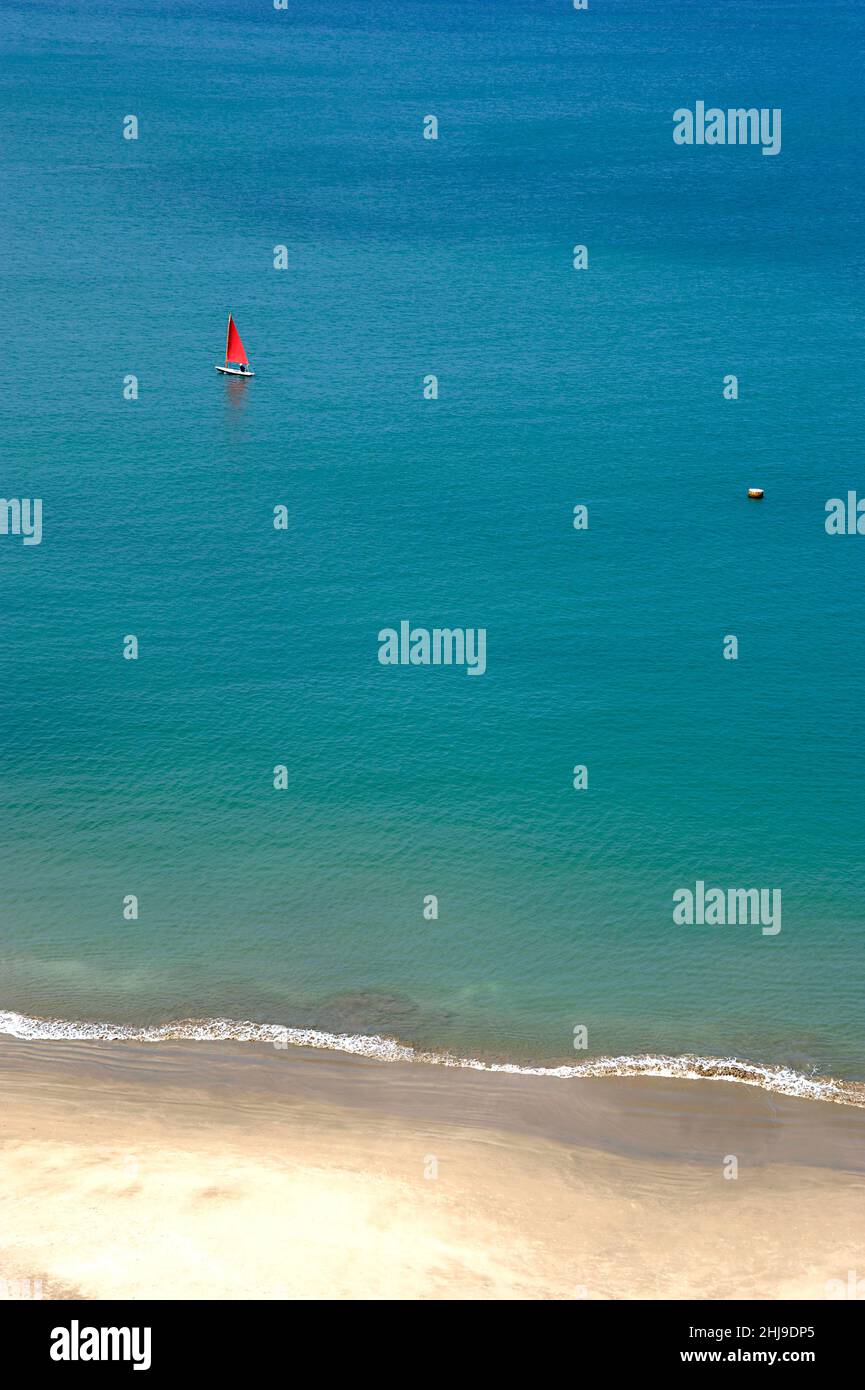 Background with a small red sail in the middle of a huge transparent blue Stock Photo