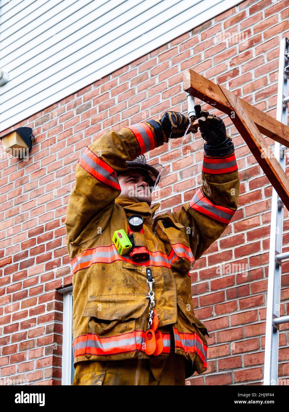 Firefighters drill on sprinkler system in turnout gear Stock Photo Alamy