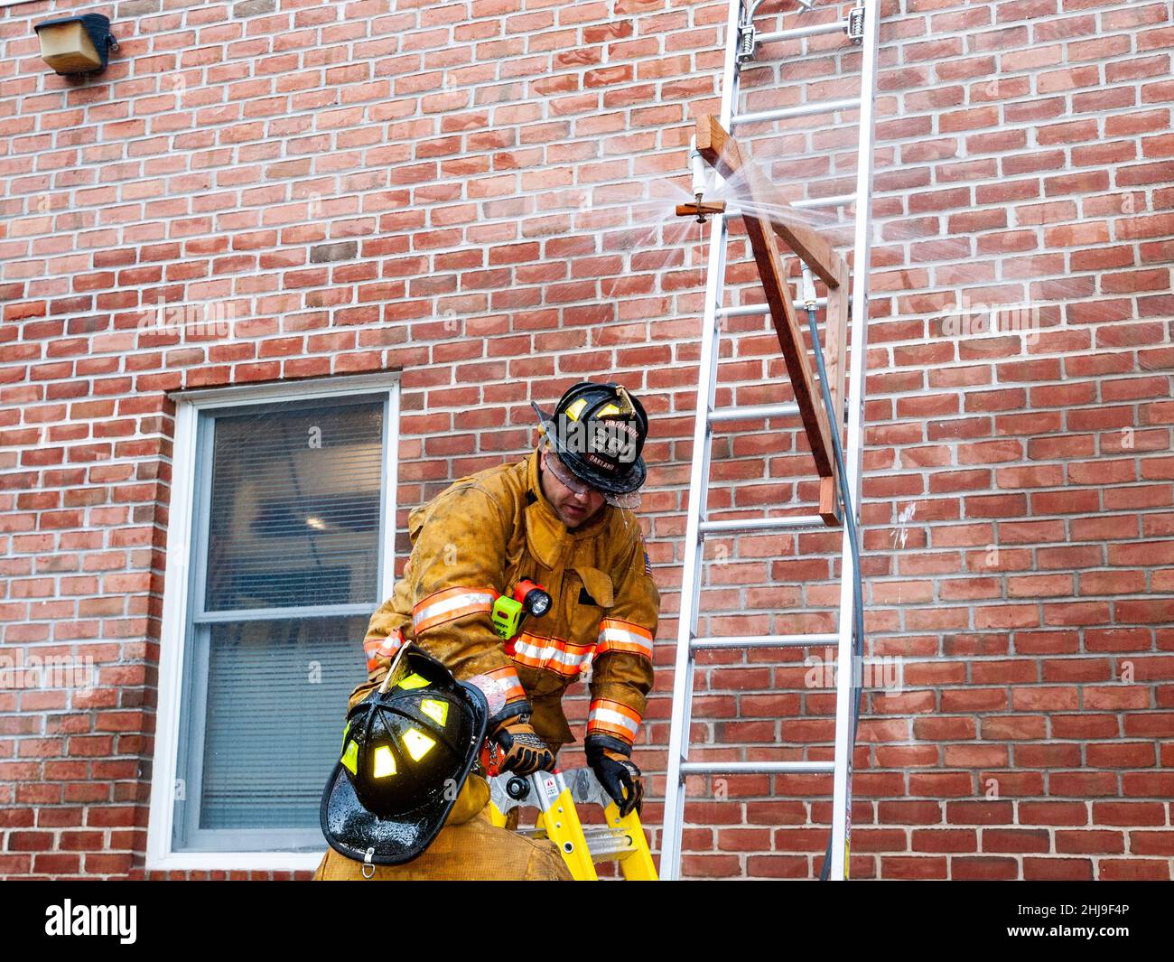 Firefighters drill on sprinkler system in turnout gear Stock Photo Alamy