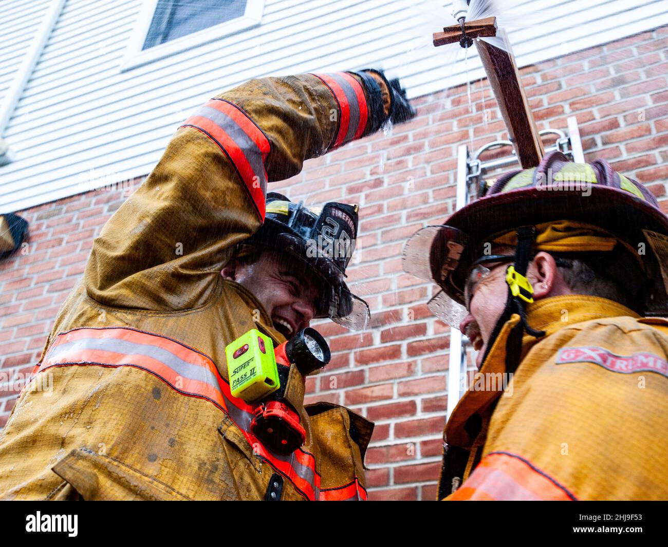 Firefighters drill on sprinkler system in turnout gear Stock Photo Alamy