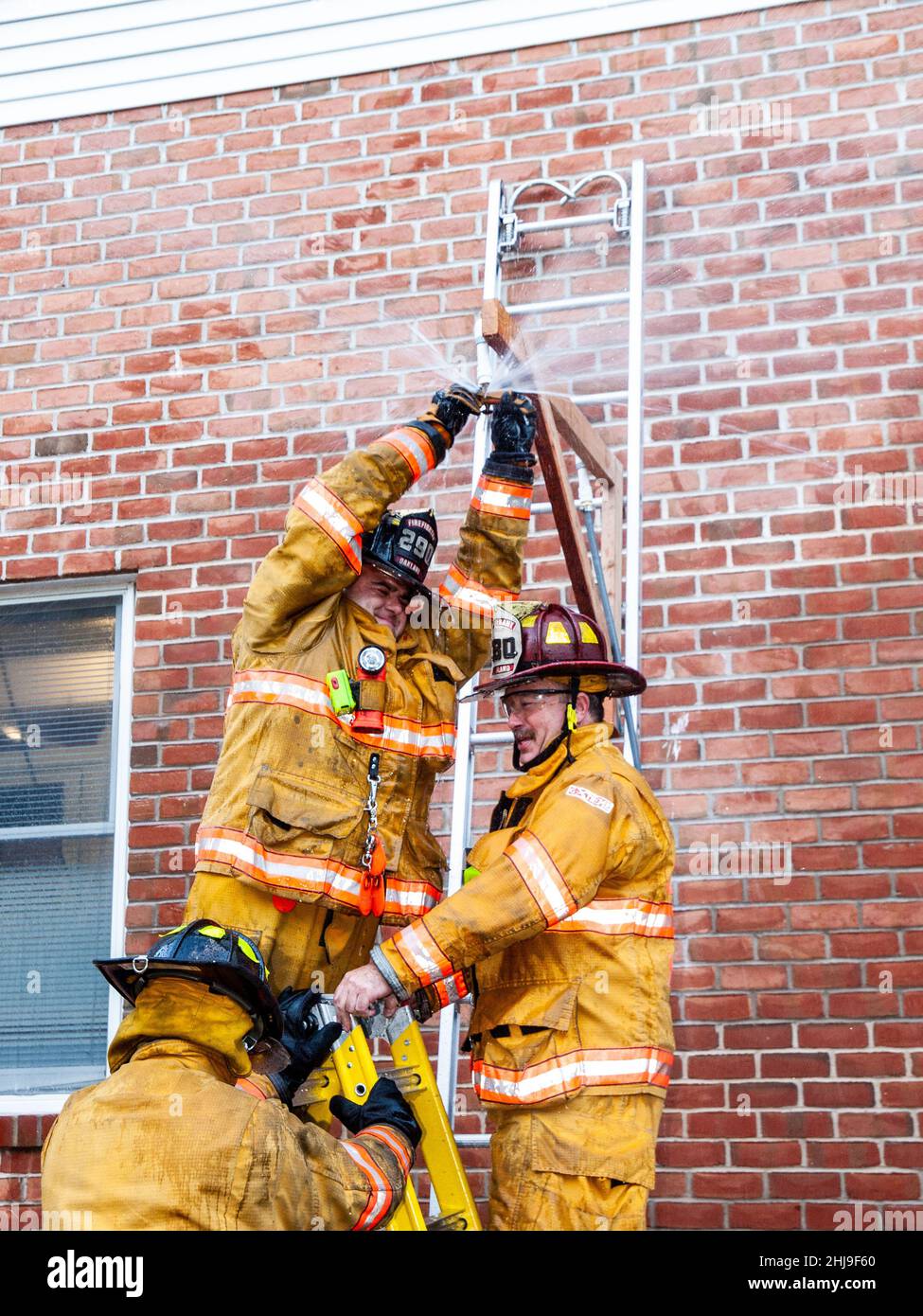 Firefighters drill on sprinkler system in turnout gear Stock Photo Alamy