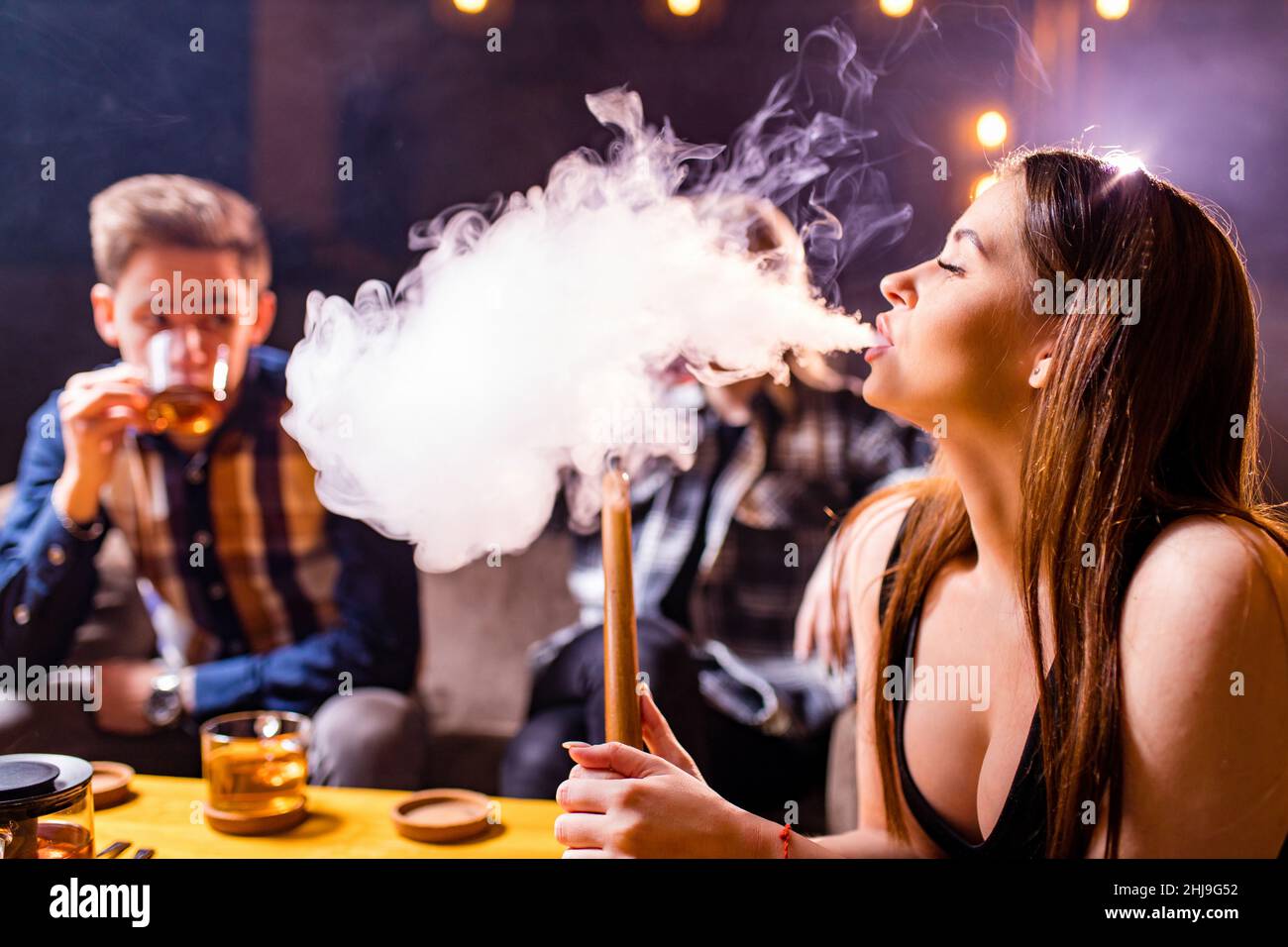 Friends party in hookah lounge smoking shisha night time Stock Photo