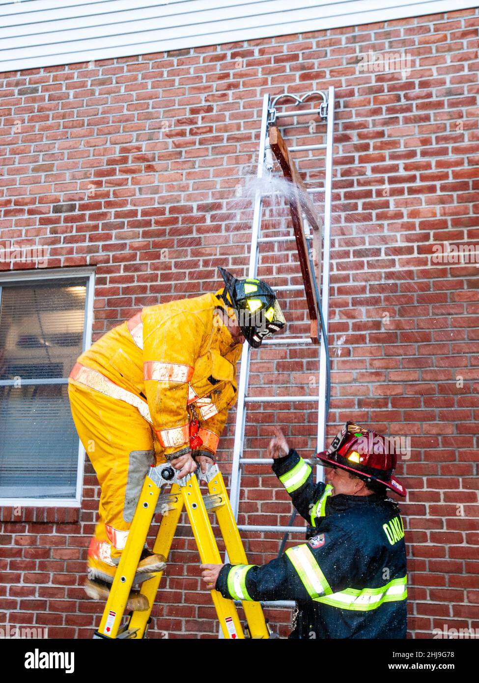 Firefighters drill on sprinkler system in turnout gear Stock Photo Alamy