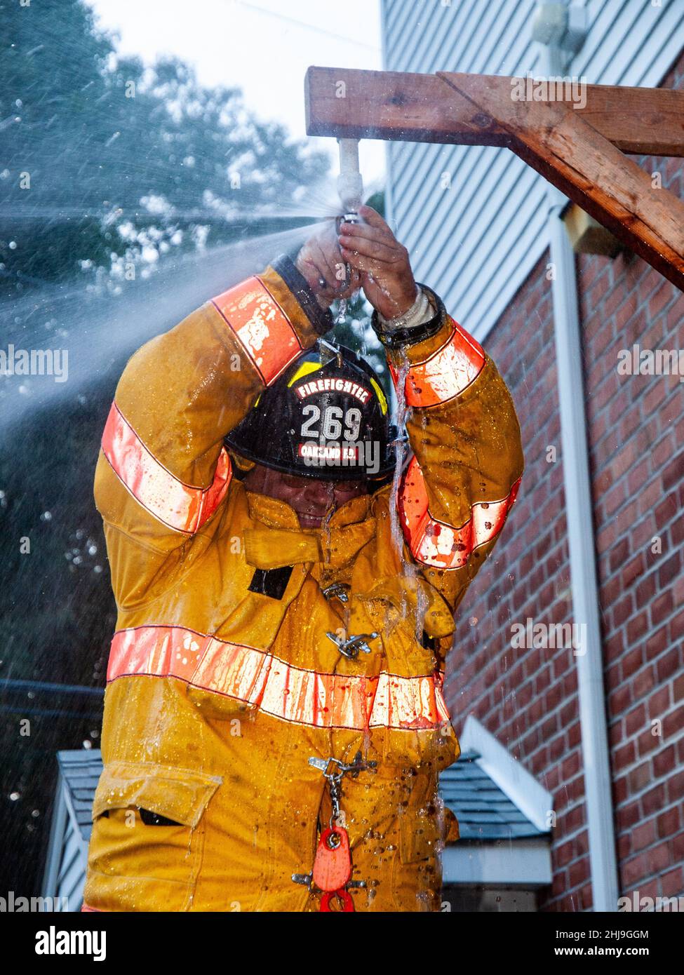 Firefighters drill on sprinkler system in turnout gear Stock Photo Alamy