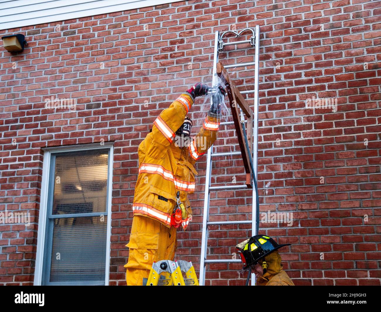 Firefighters drill on sprinkler system in turnout gear Stock Photo Alamy
