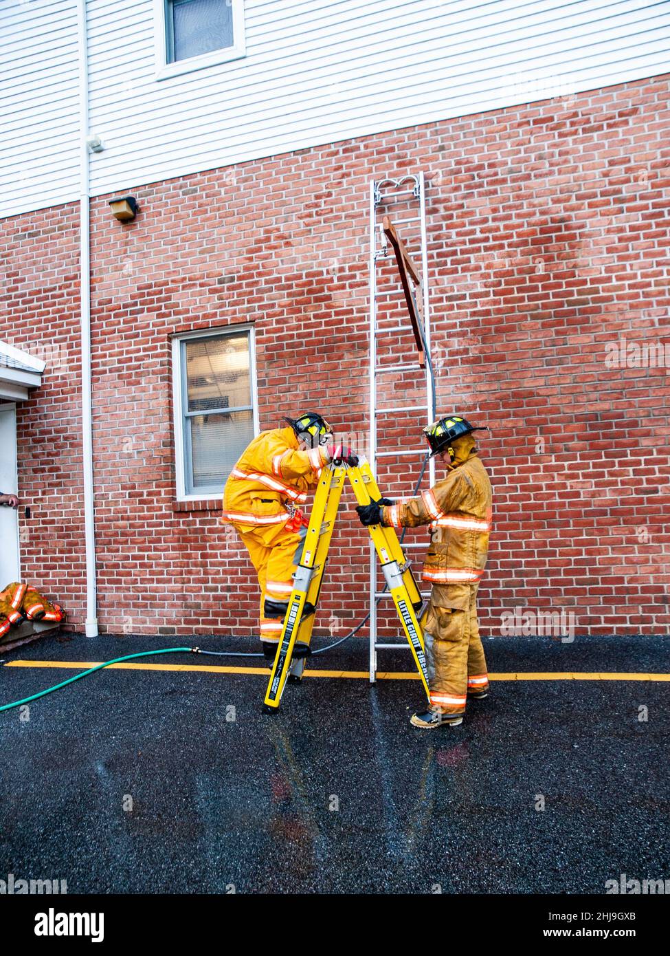 Firefighters drill on sprinkler system in turnout gear Stock Photo Alamy