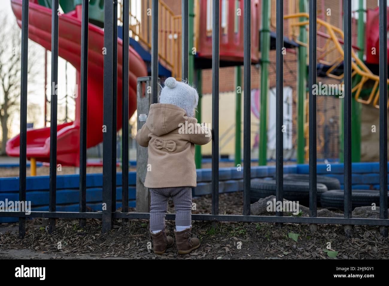 Child is looking at the closed empty playground from outside during lockdown due to covid in United Kingdom Stock Photo