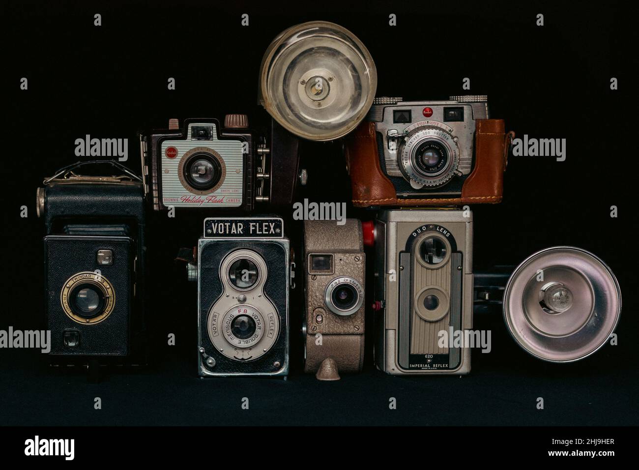Collection of old retro vintage cameras on black background, including