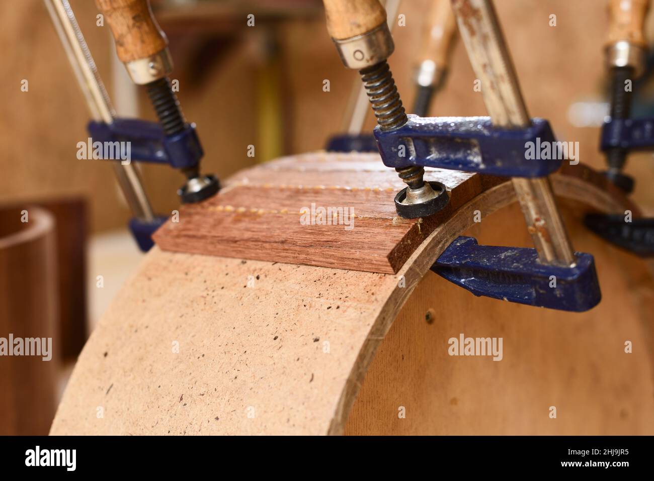 Part of handmade wooden drum held in clamp closeup Stock Photo