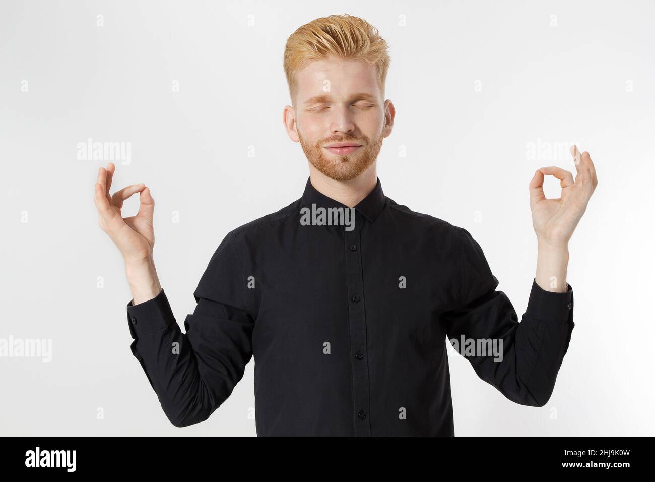 Practice meditation for business success concept. Young man Master stress and prime for success, overcome anxiety. Close up of redheaded guy in medita Stock Photo