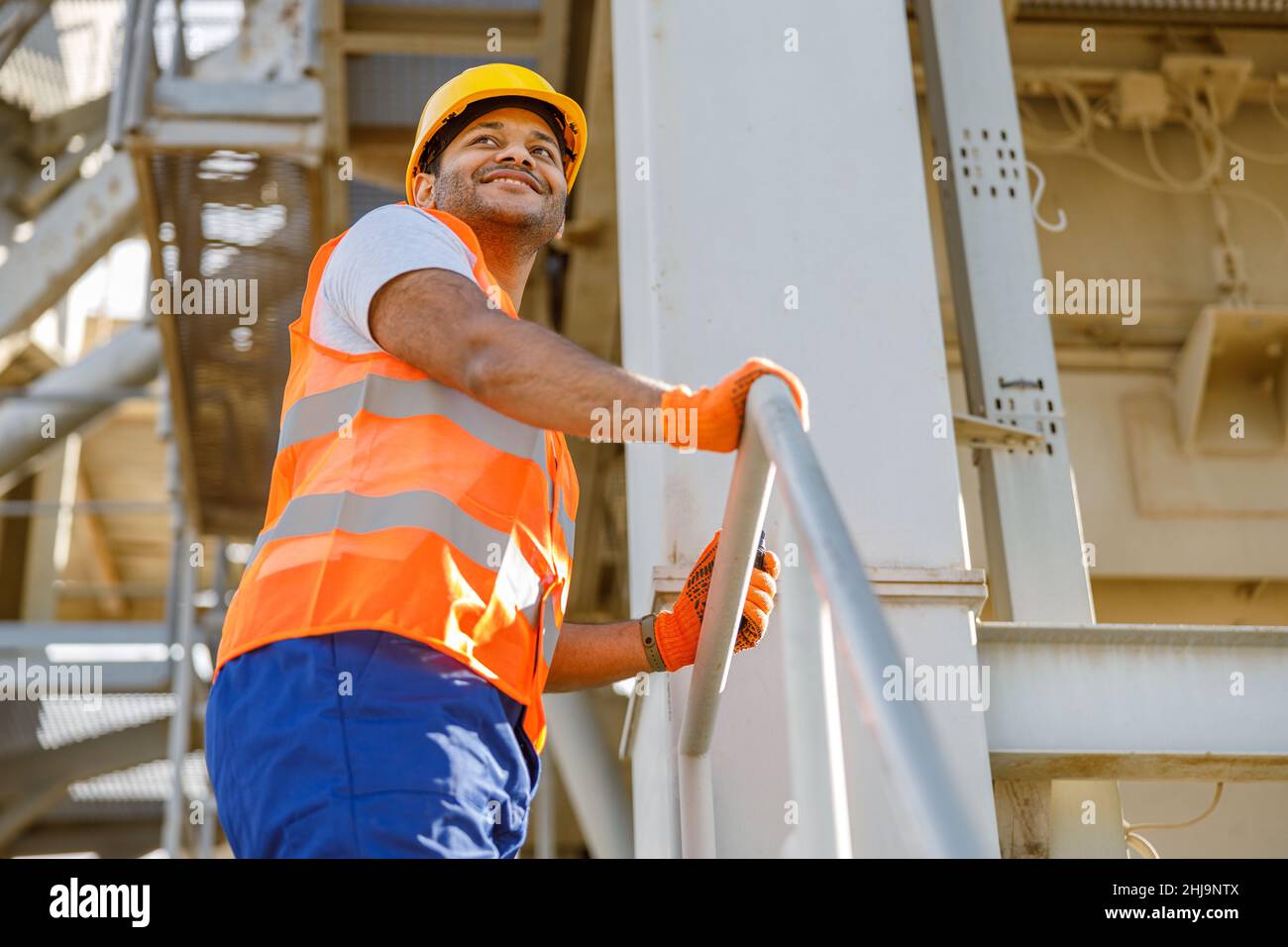 Smiling young construction engineer working in plant Stock Photo