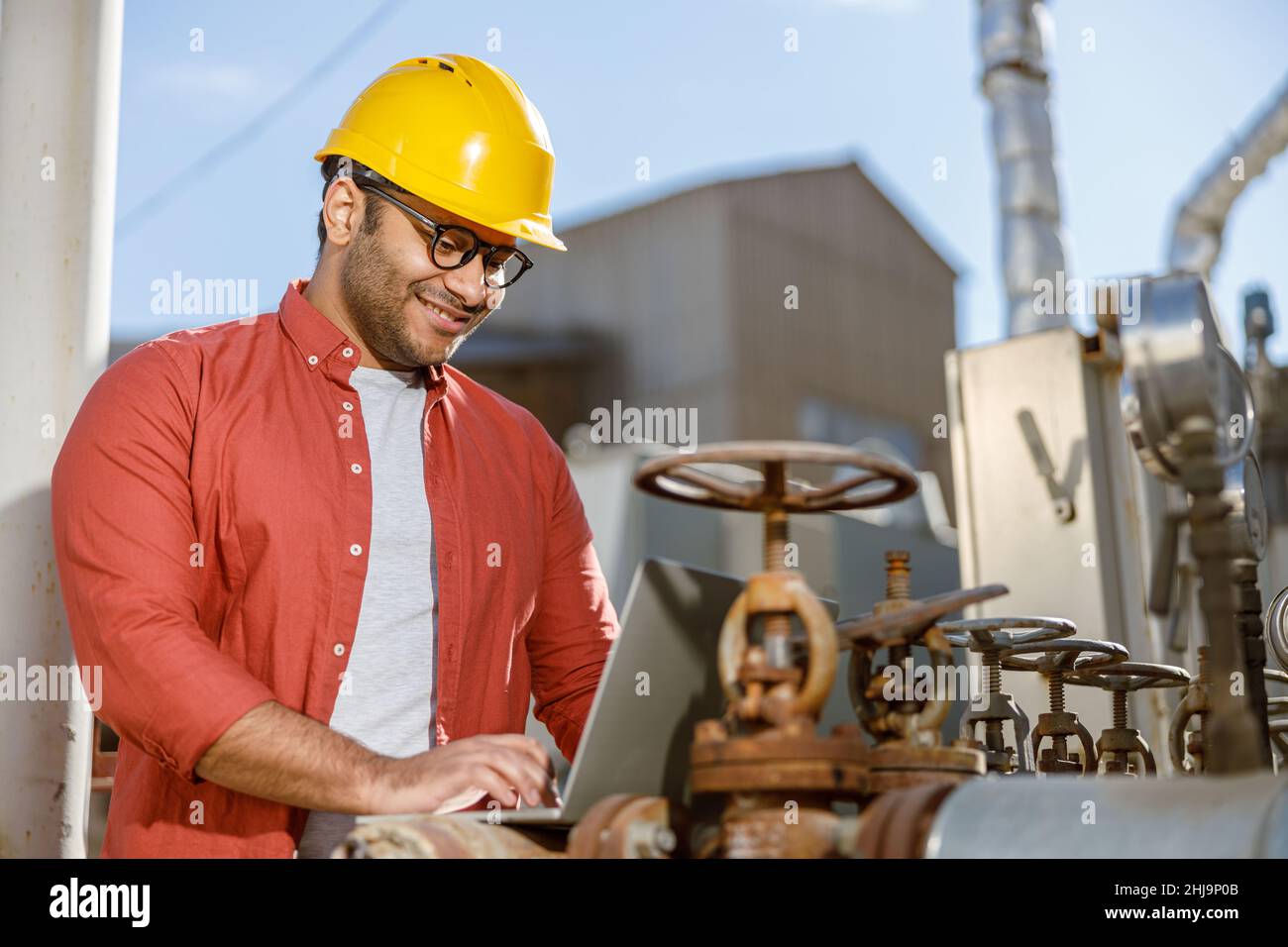 Smiling young construction specialist working in plant Stock Photo