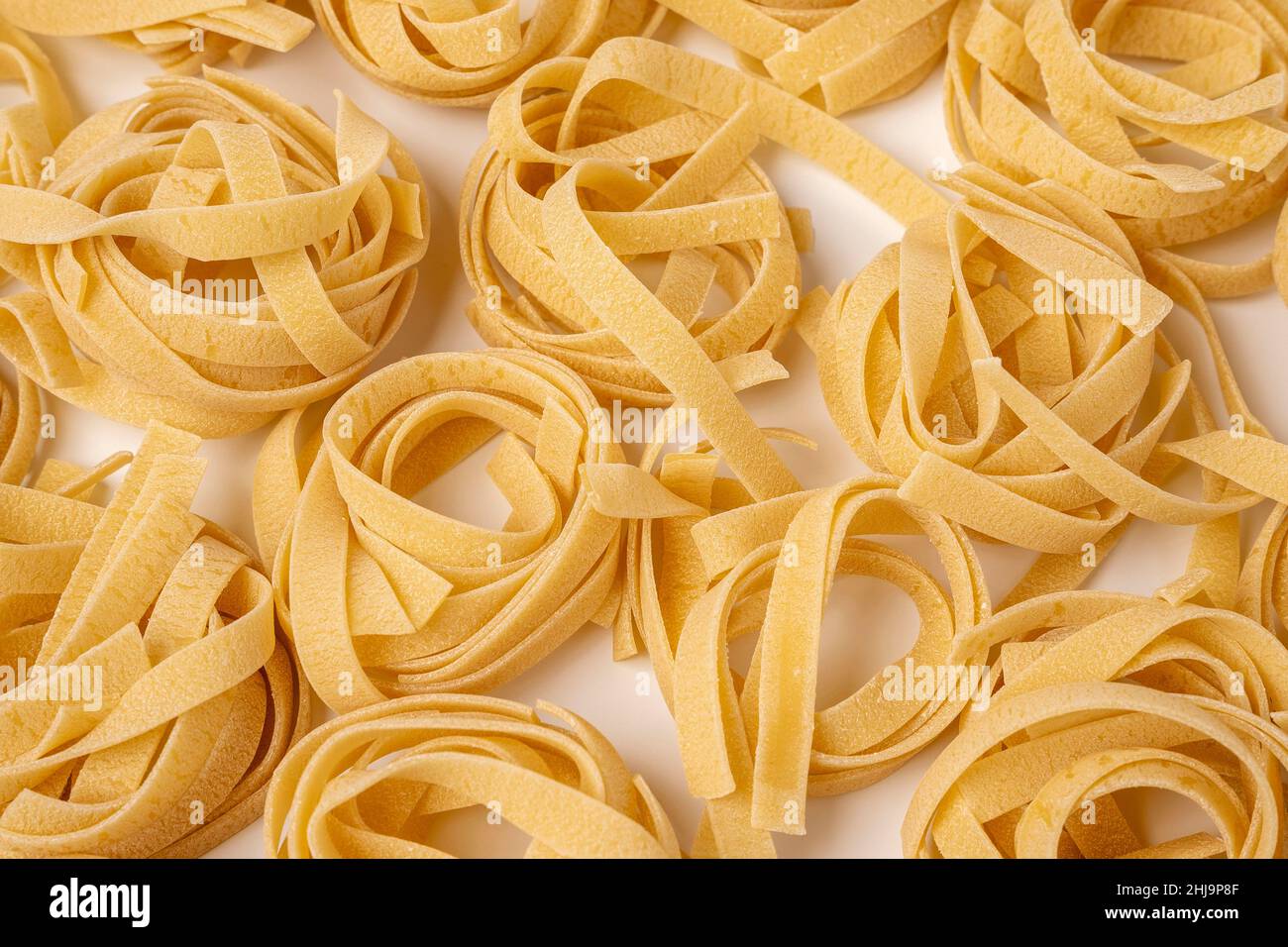 Raw tagliatelle , nest pasta, Egg pasta nests lying in a pattern on a