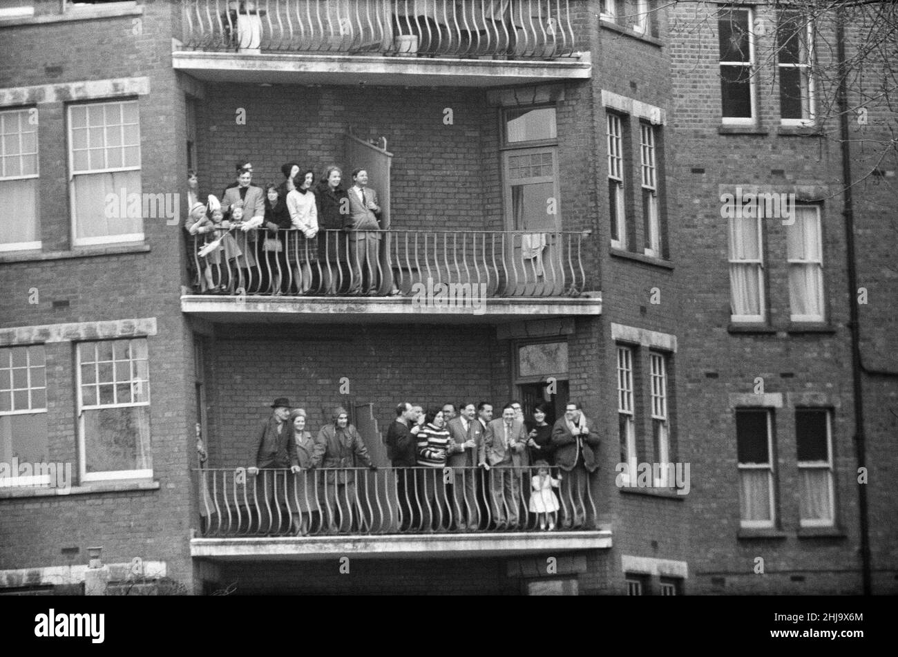 Oxford verses Cambridge Boat Race, on The River Thames, London, 23rd March 1963.   Onlookers enjoy the day from a residence in the Barnes area.  The 109th Boat Race took place on 23 March 1963. Held annually, the event is a side-by-side rowing race between crews from the Universities of Oxford and Cambridge along the River Thames. The race, umpired by Gerald Ellison, the Bishop of Chester, was won by Oxford with a winning margin of five lengths.  Picture taken 23rd March 1963 Stock Photo