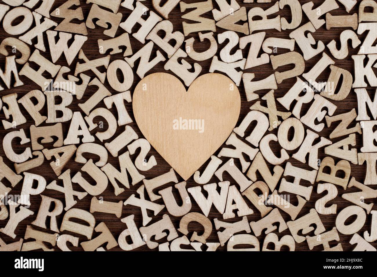 Vintage Wooden Heart Surrounded by Wooden Letters Background. Stock Photo