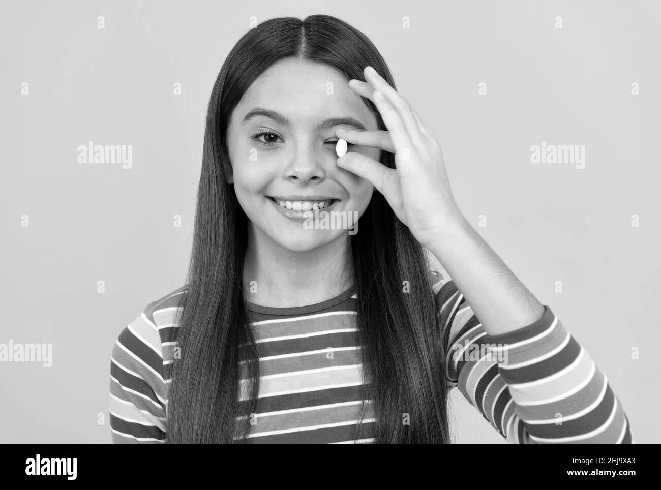 teen girl with natural pill products. presenting vitamin product. happy child with pill. Stock Photo