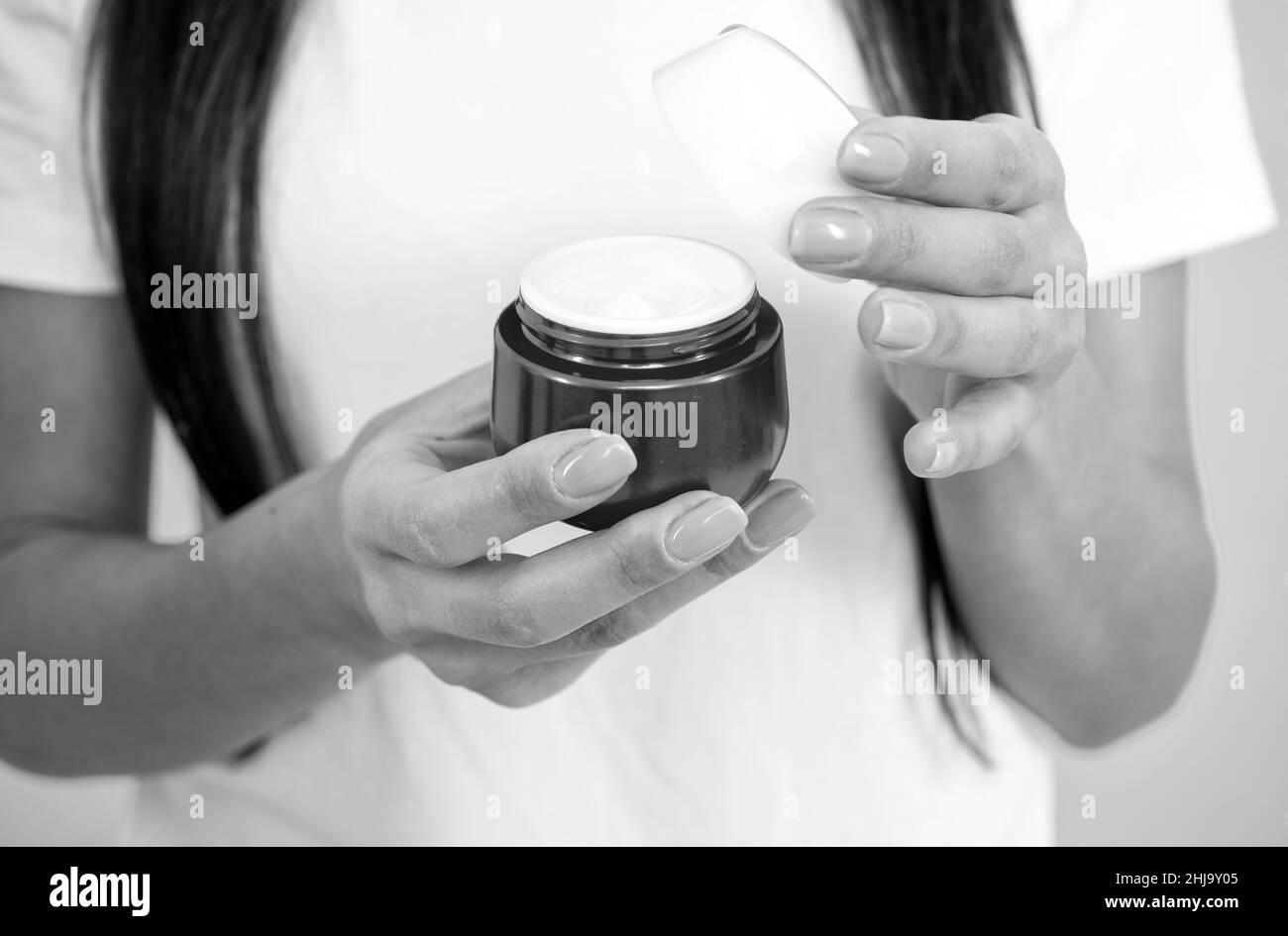 presenting cosmetic product for skin. open hand cream. hand manicure. female applying skin cream. Stock Photo