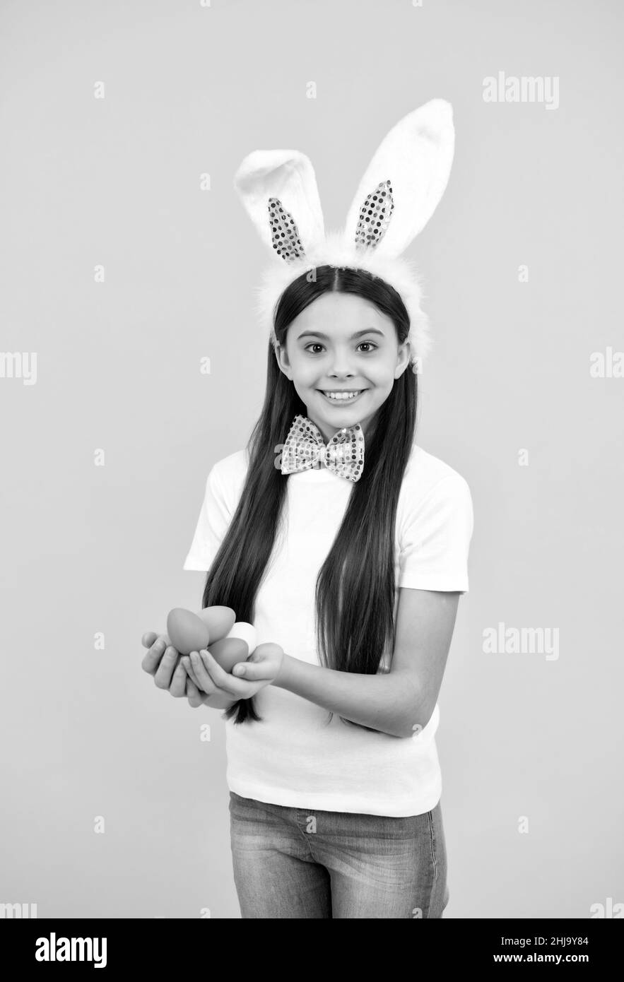 happy easter holiday. funny child in rabbit ears. smiling teenager girl in bow tie. bunny egg hunt. Stock Photo
