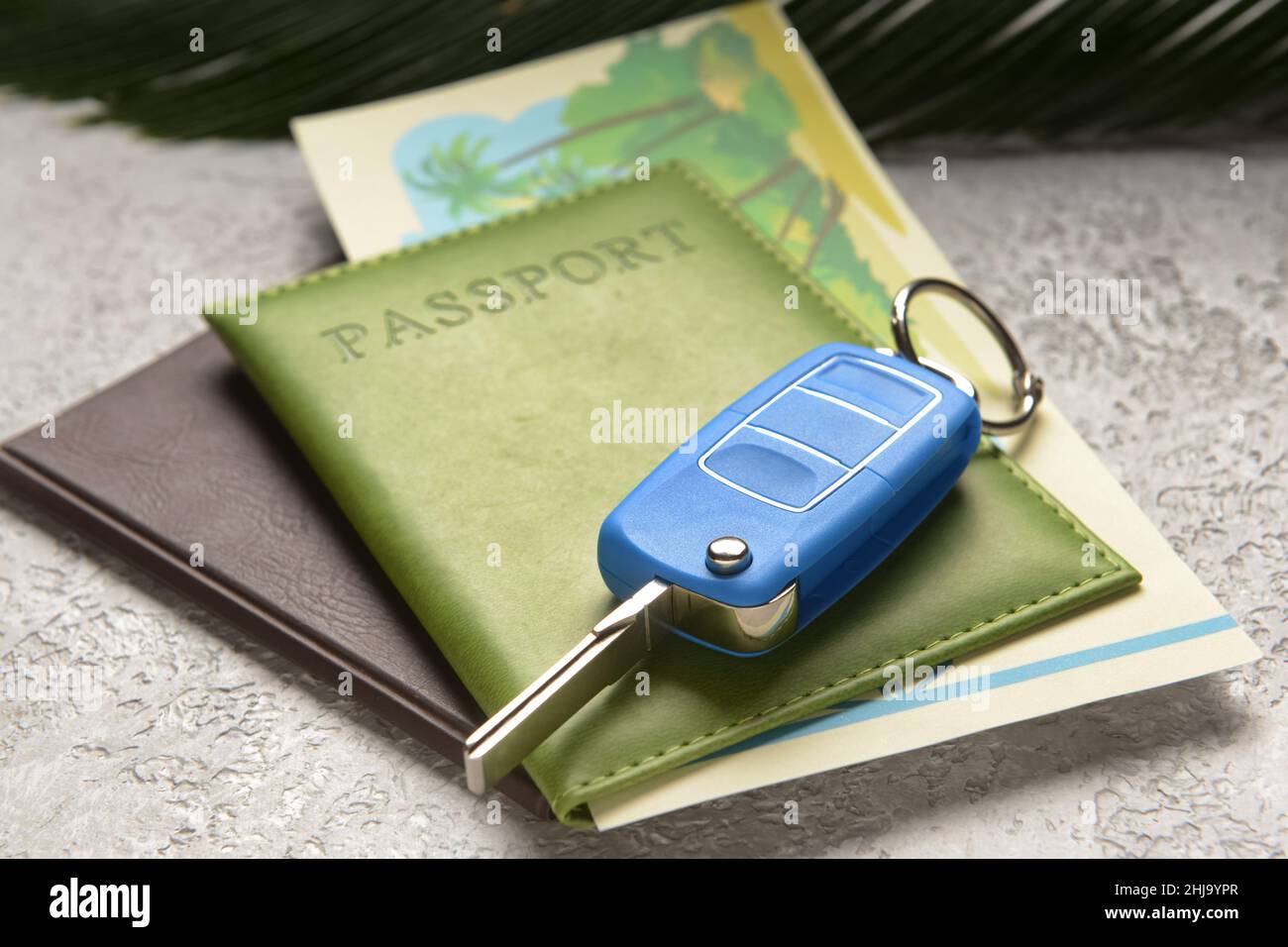 Key fob with passports on grunge background, closeup. Car rental