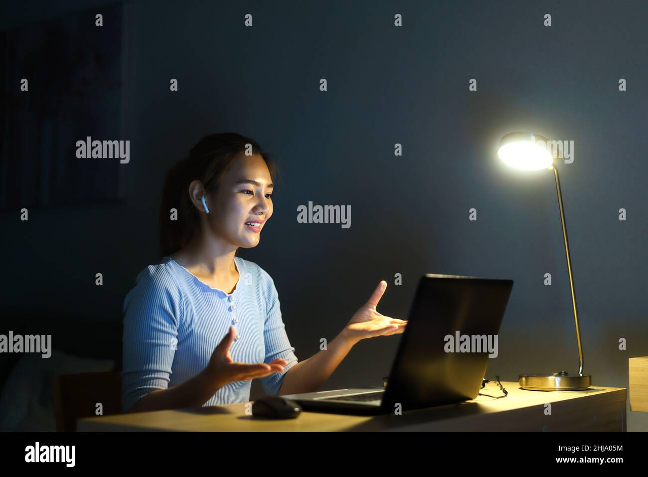 Asian woman work at home are sitting at work with colleagues or managers via video call at night at home. Stock Photo