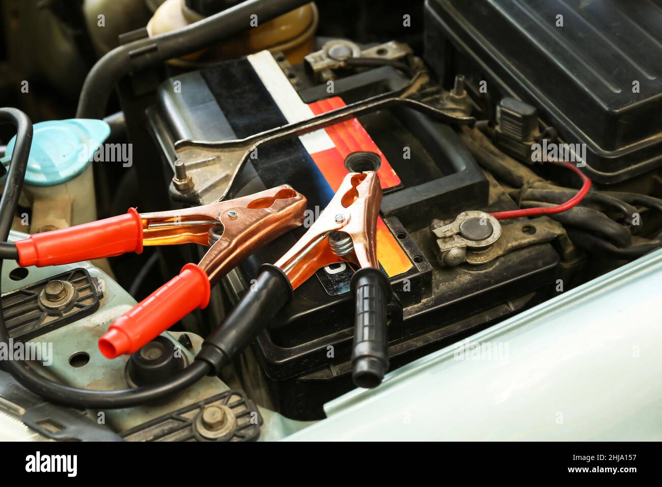 Modern car battery and charger in hood Stock Photo Alamy