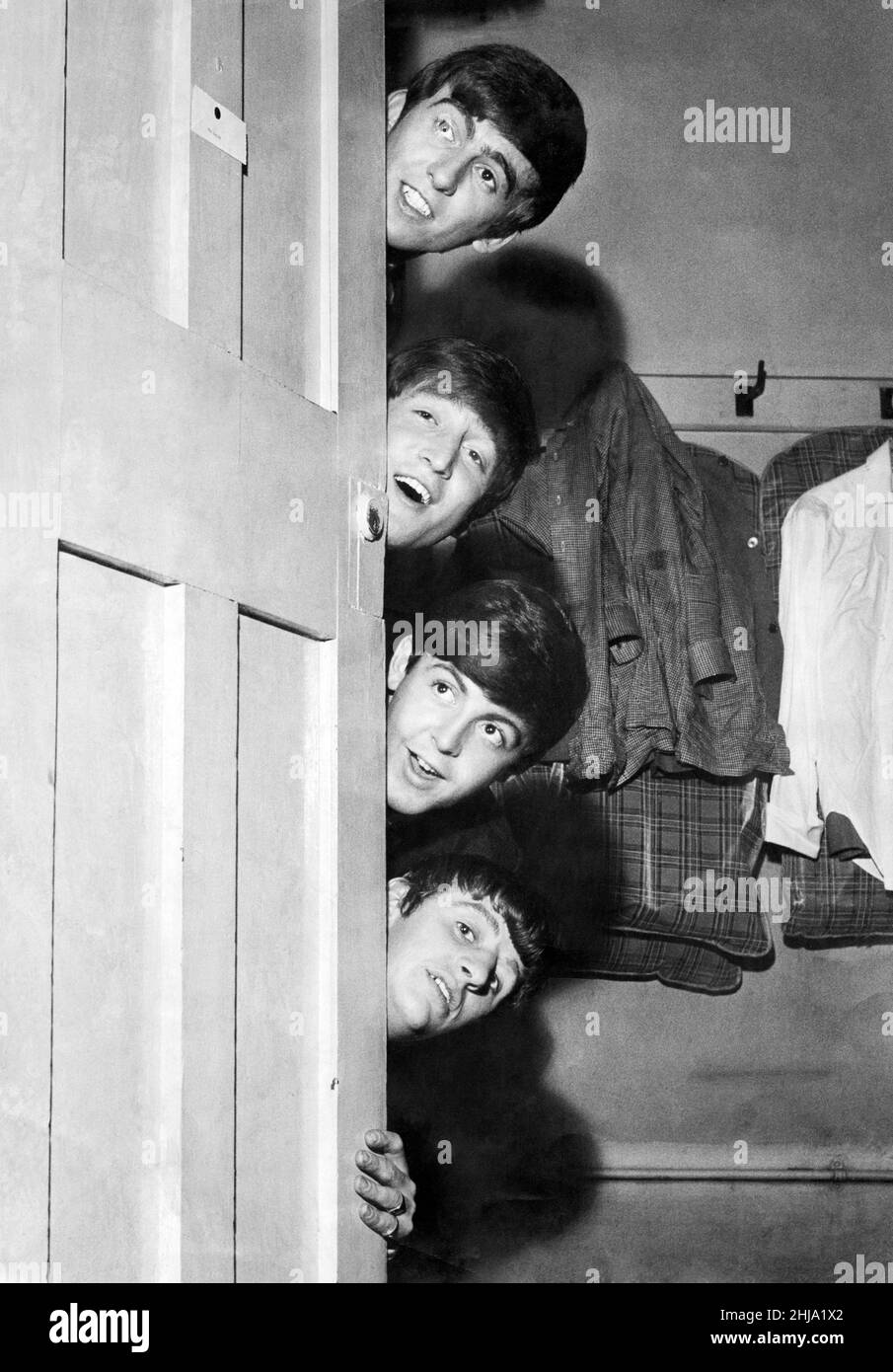 The Beatles peering out from behind their dressing room door before their appearance at the Odeon Theatre in Manchester.Top to bottom: George Harrison, John Lennon, Paul McCartney and Ringo Starr. 30th May 1963. Stock Photo