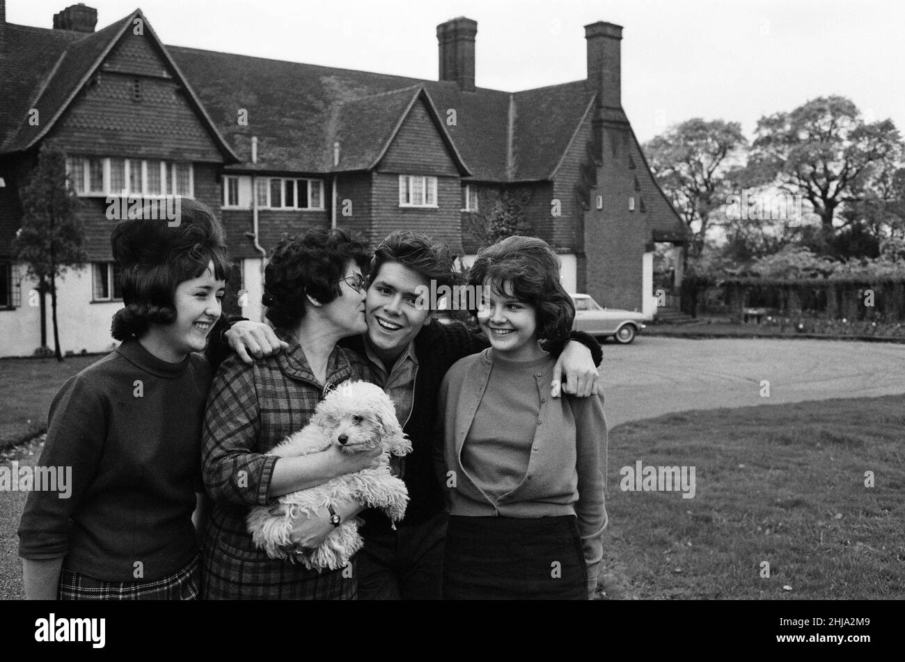 Cliff Richard at his tudor style mansion at Upper Nazeing, Essex. He will live there with his mother and two sisters Jackie 16 and Joan 13. It has six bedrooms, a garage for five cars and is set in eleven acres of ground, the price was ¿30,000. Cliff with his mother Mrs Dorothy Webb (wearing glasses), and sisters Jackie (check skirt) and Joan. 10th November 1963. Stock Photo