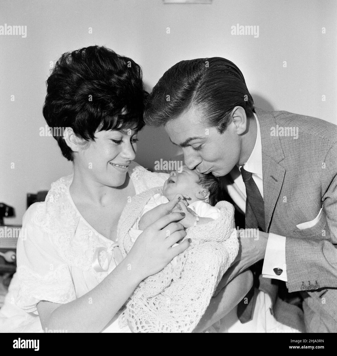 Gillian Vaughan, wife of comedian Des O'Connor, had a baby daughter five days ago, their first child. Tracy Jane was photographed with her parents in the Lindo Wing of St Mary's Hospital, Paddington. Tracy has a lot of dark hair and weighed 7lbs 2oz at birth. 26th November 1962. Stock Photo