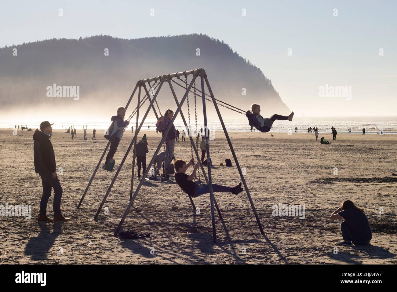 Children play on the beach swings facing the Pacific Ocean in Seaside, Oregon, on Saturday