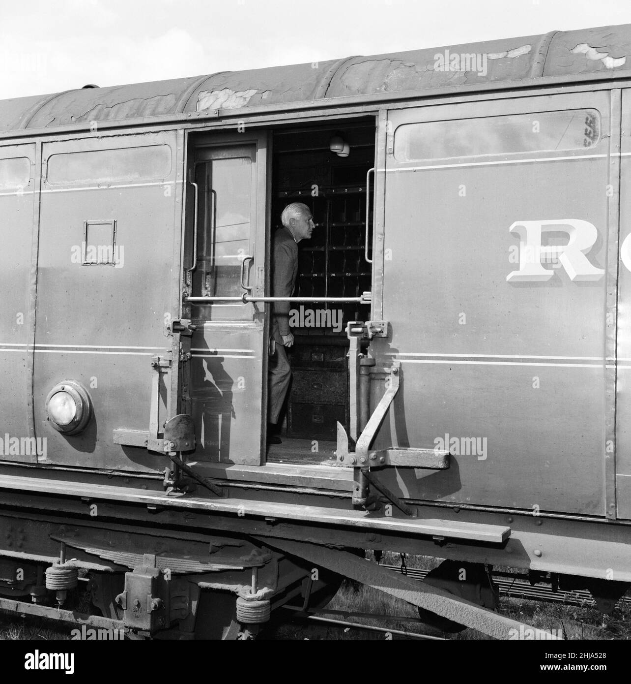 1963 Great Train Robbery was the robbery of ¿2.6 million from a Royal Mail train heading from Glasgow to London on the West Coast Main Line in the early hours of 8th August 1963, at Bridego Railway Bridge, Ledburn, near Mentmore in Buckinghamshire, England. Our Picture Shows ... Detective Superintendent Malcolm Fewtrell, Head of Buckinghamshire CID examines the mail carriage in the sidings at Cheddington Train Station, Friday 9th August 1963. Stock Photo