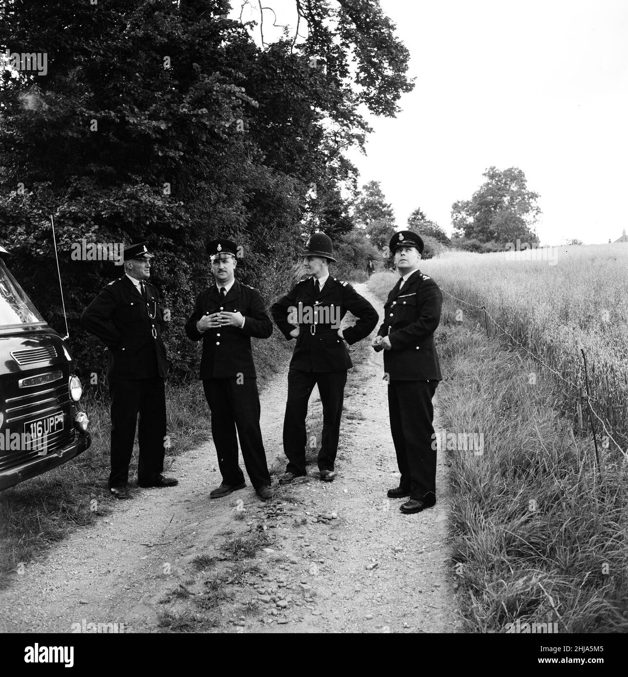 Leatherslade Farm, between Oakley and Brill in Buckinghamshire, hideout used by gang, 27 miles from the crime scene, Tuesday 13th August 1963. Our Picture Shows ... Police Officers guard access to country lane leading up to remote farmhouse used as hideaway by gang in immediate aftermath of robbery.   The 1963 Great Train Robbery was the robbery of 2.6 million pounds from a Royal Mail train heading from Glasgow to London on the West Coast Main Line in the early hours of 8th August 1963, at Bridego Railway Bridge, Ledburn, near Mentmore in  Buckinghamshire, England. Stock Photo