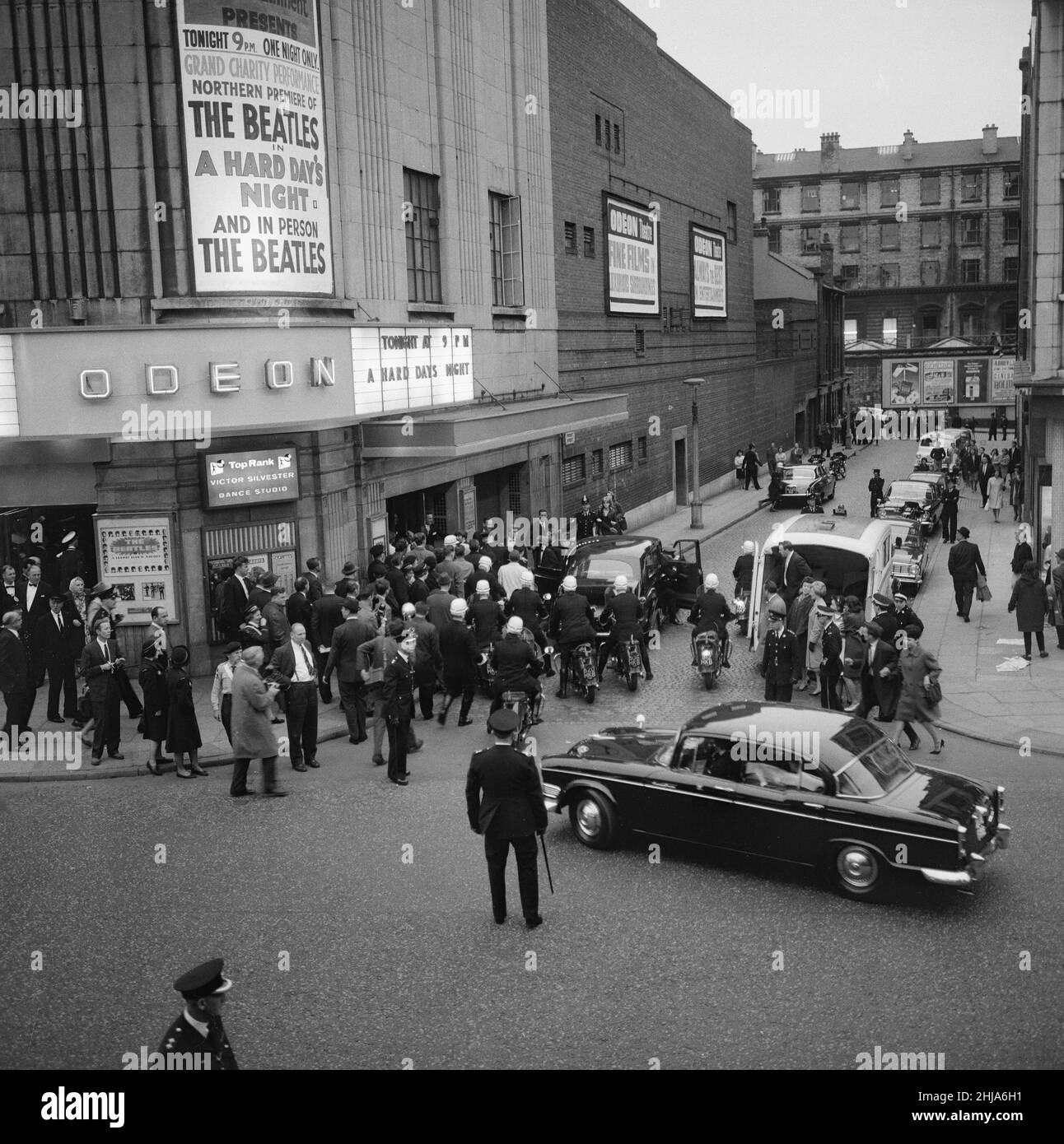 Four days after the world premiere of A Hard Day's Night in London, The Beatles arrived in Liverpool for the northern England premiere 10th July 1964. The Beatles flew to the city and were greeted upon arrival at Speke Airport by 3,000 fans.  The Beatles were driven to Liverpool Town Hall in a police cavalcade, with an estimated 200,000 people lining the route.  Inside the town hall, Lord Mayor Alderman Louis Caplan, gave a speech from the Minstrel's Gallery to the 714 guests present in the ballroom and The Beatles were each presented with a key to the city.  Just before 9pm they left in an Au Stock Photo