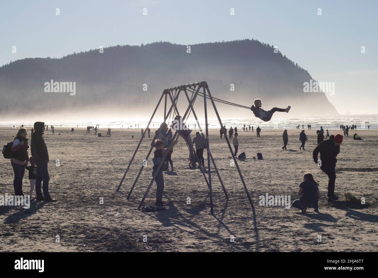 Children play on the beach swings facing the Pacific Ocean in Seaside, Oregon, on Saturday